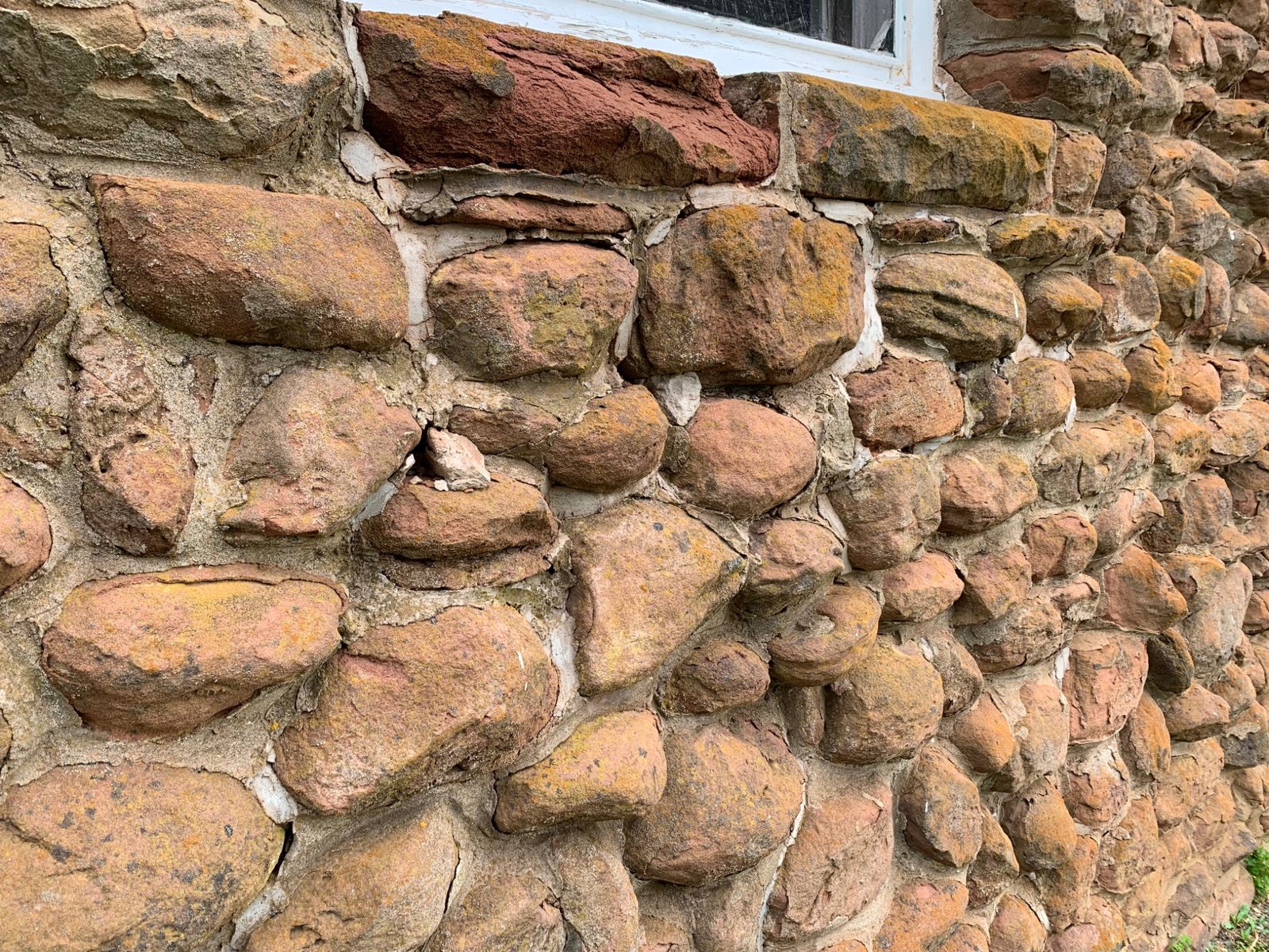 Historic sandstone masonry at Dalvay by the Sea showing weathering and localized deterioration before restoration