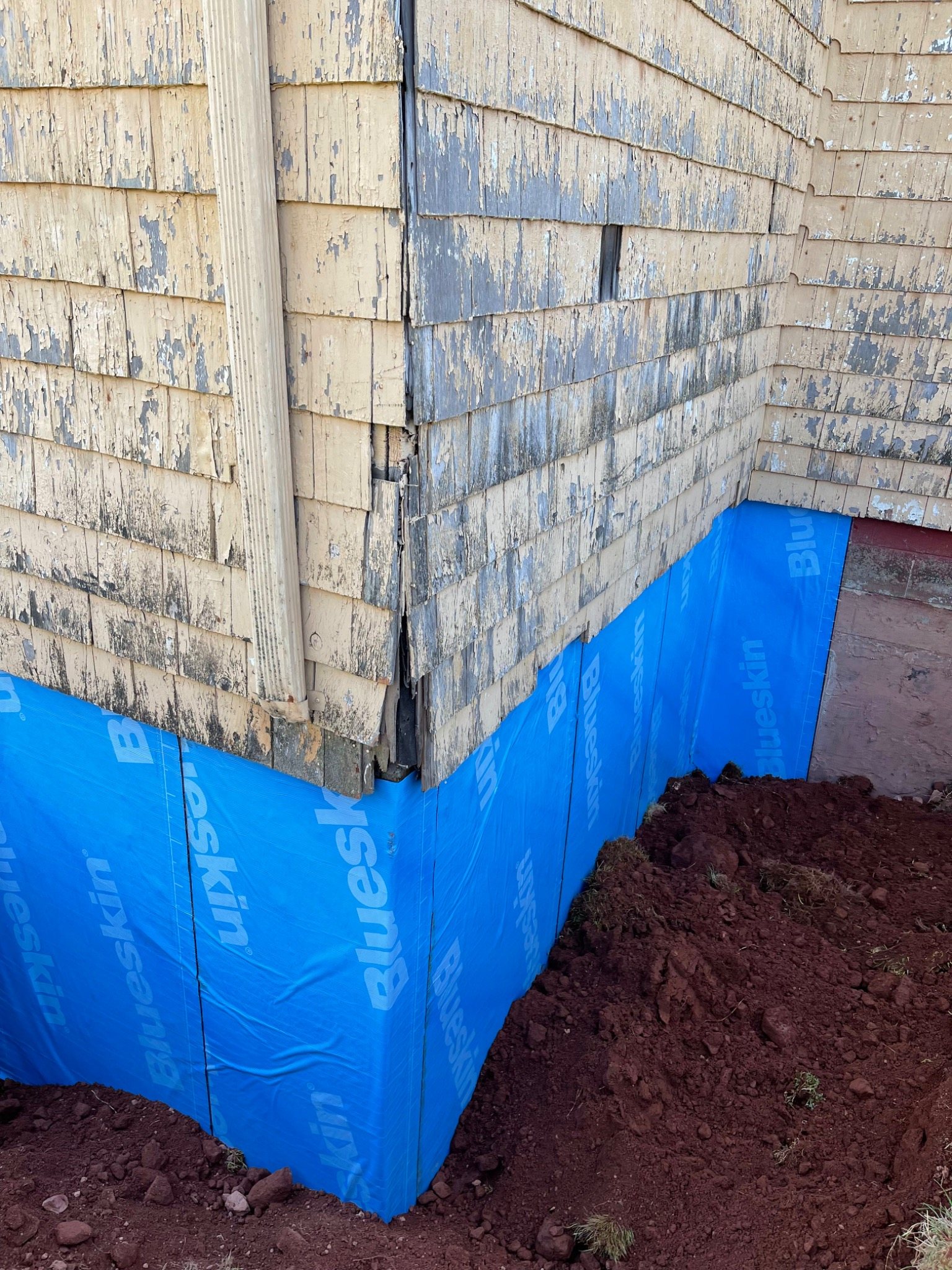 Exterior waterproofing membrane on a repaired foundation before backfilling
