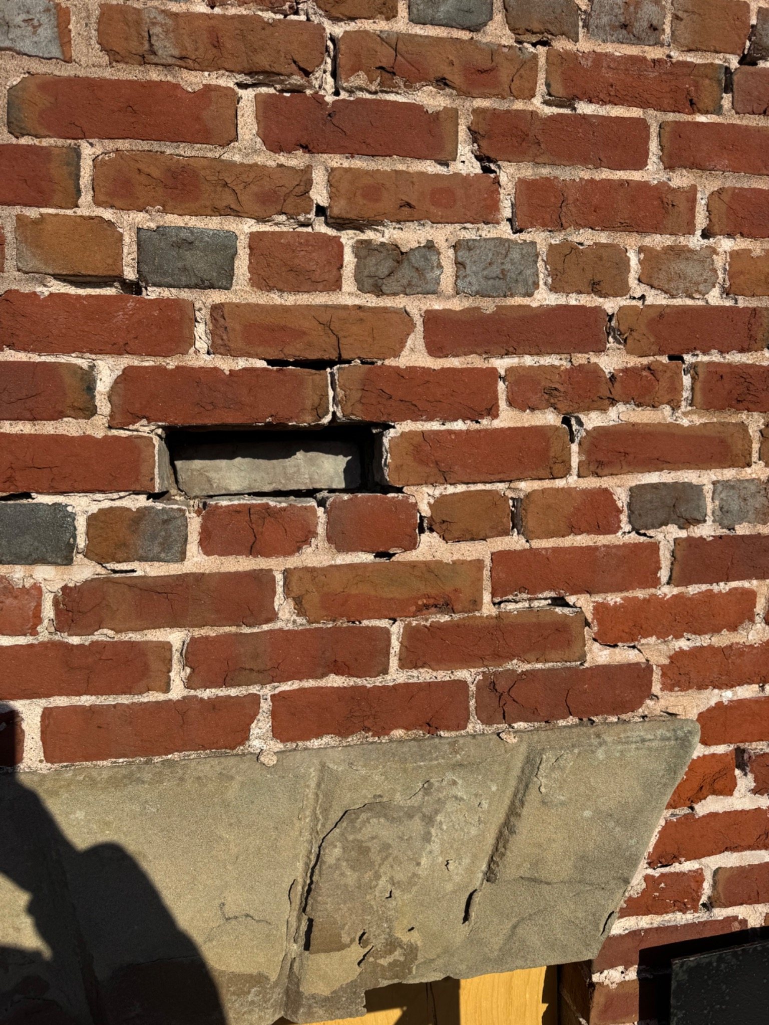 Historic brick wall with deep open joints and missing masonry material