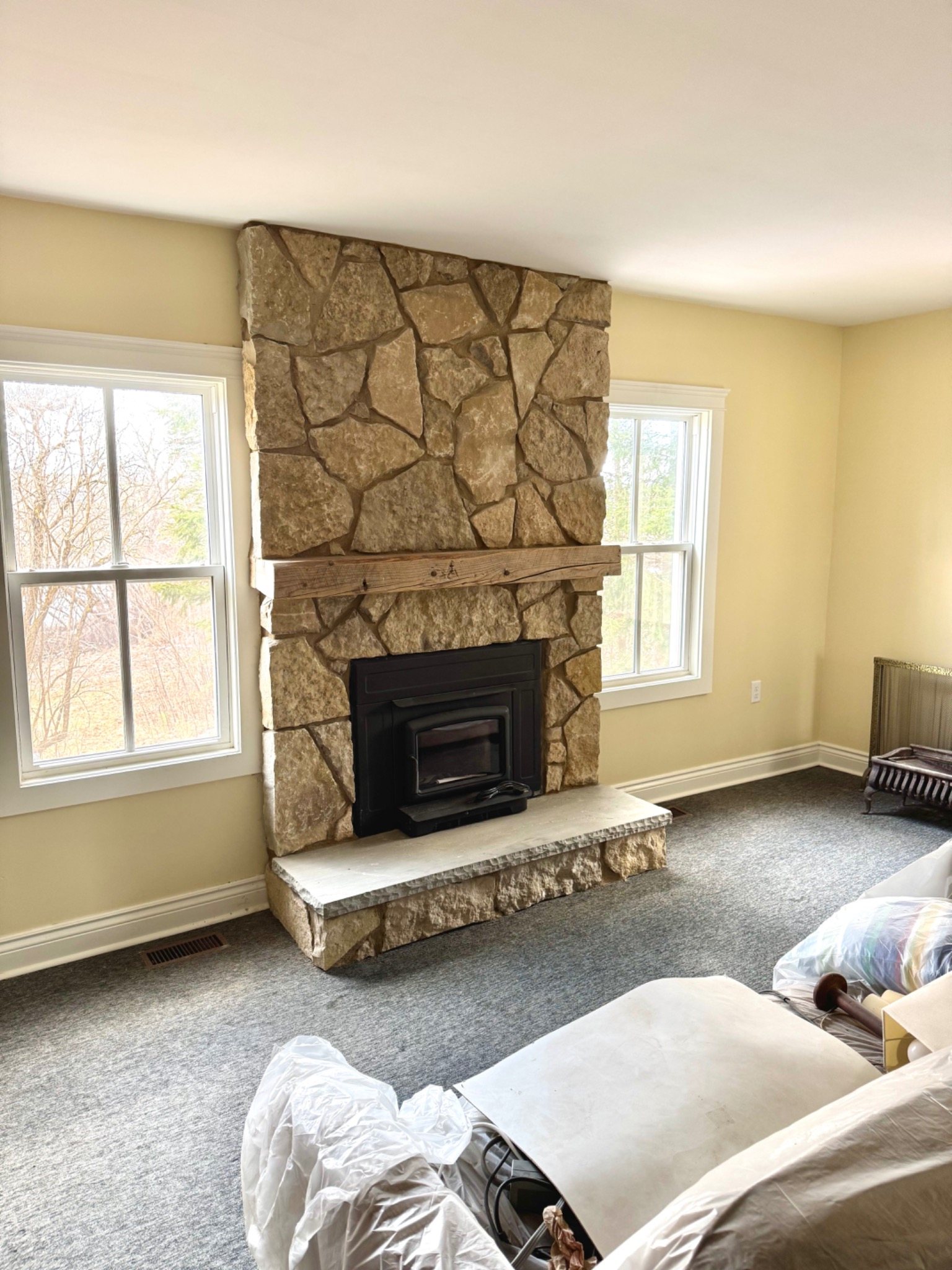 Stone fireplace with a fitted insert showing how appliance and masonry work meet at the opening