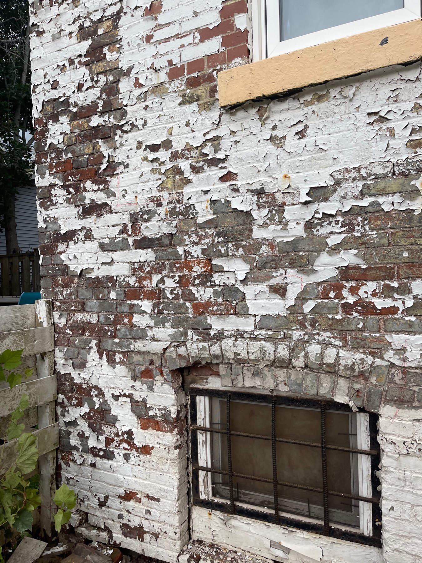 Painted brick masonry with coating failure and deterioration