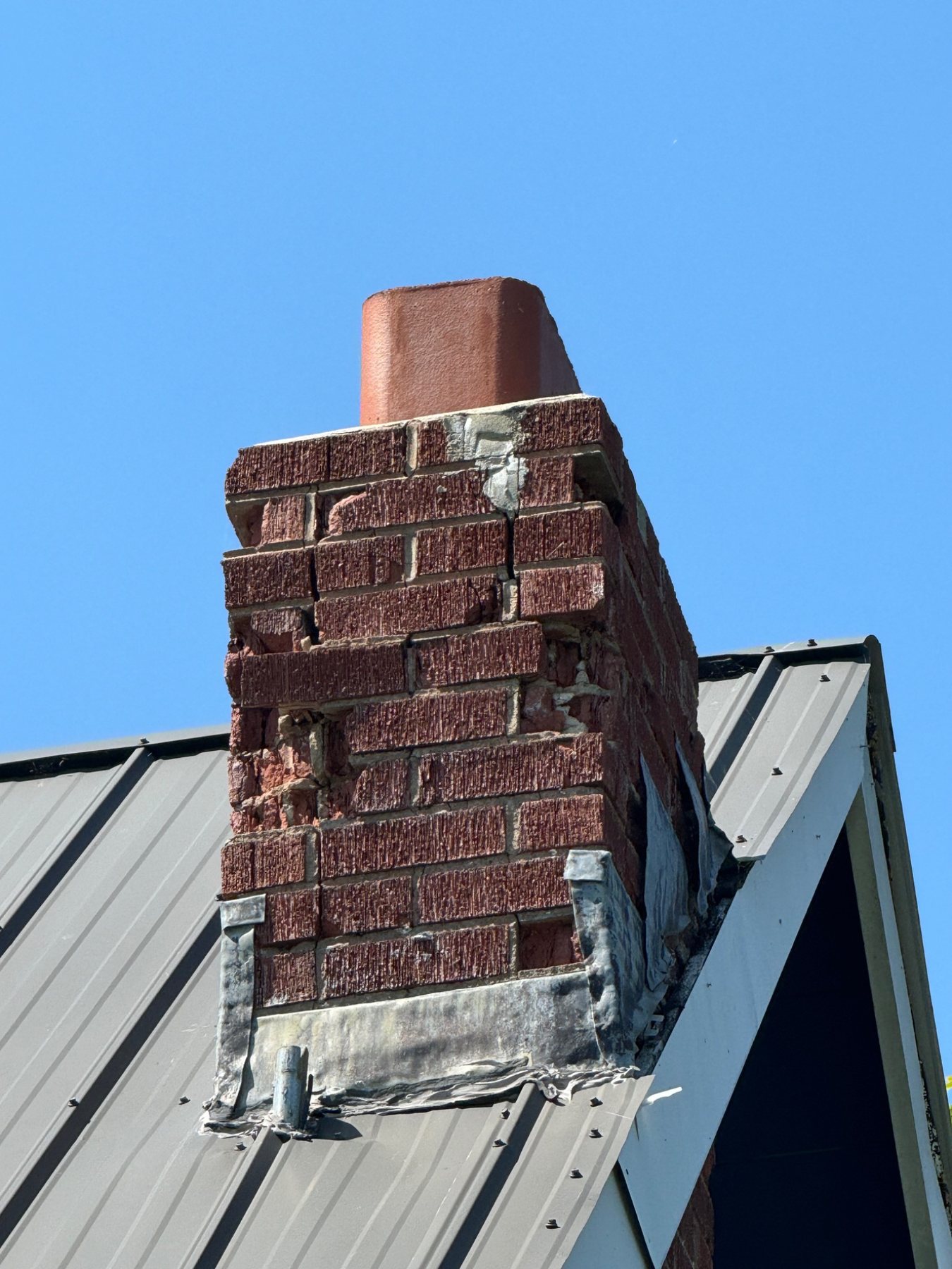 Masonry chimney with brick unit deterioration and material loss