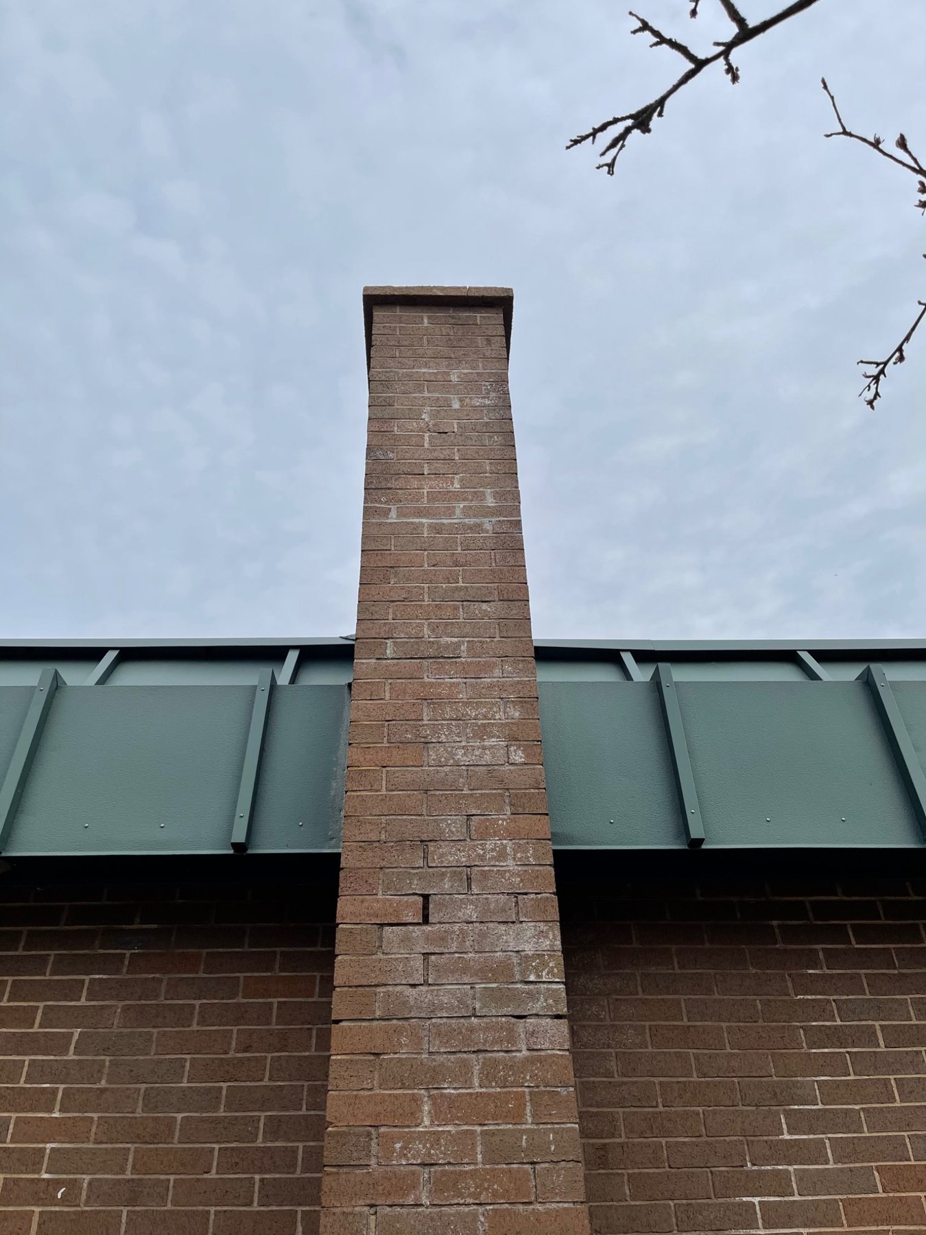 Efflorescence and mortar loss on masonry showing a different moisture-related condition from brick spalling
