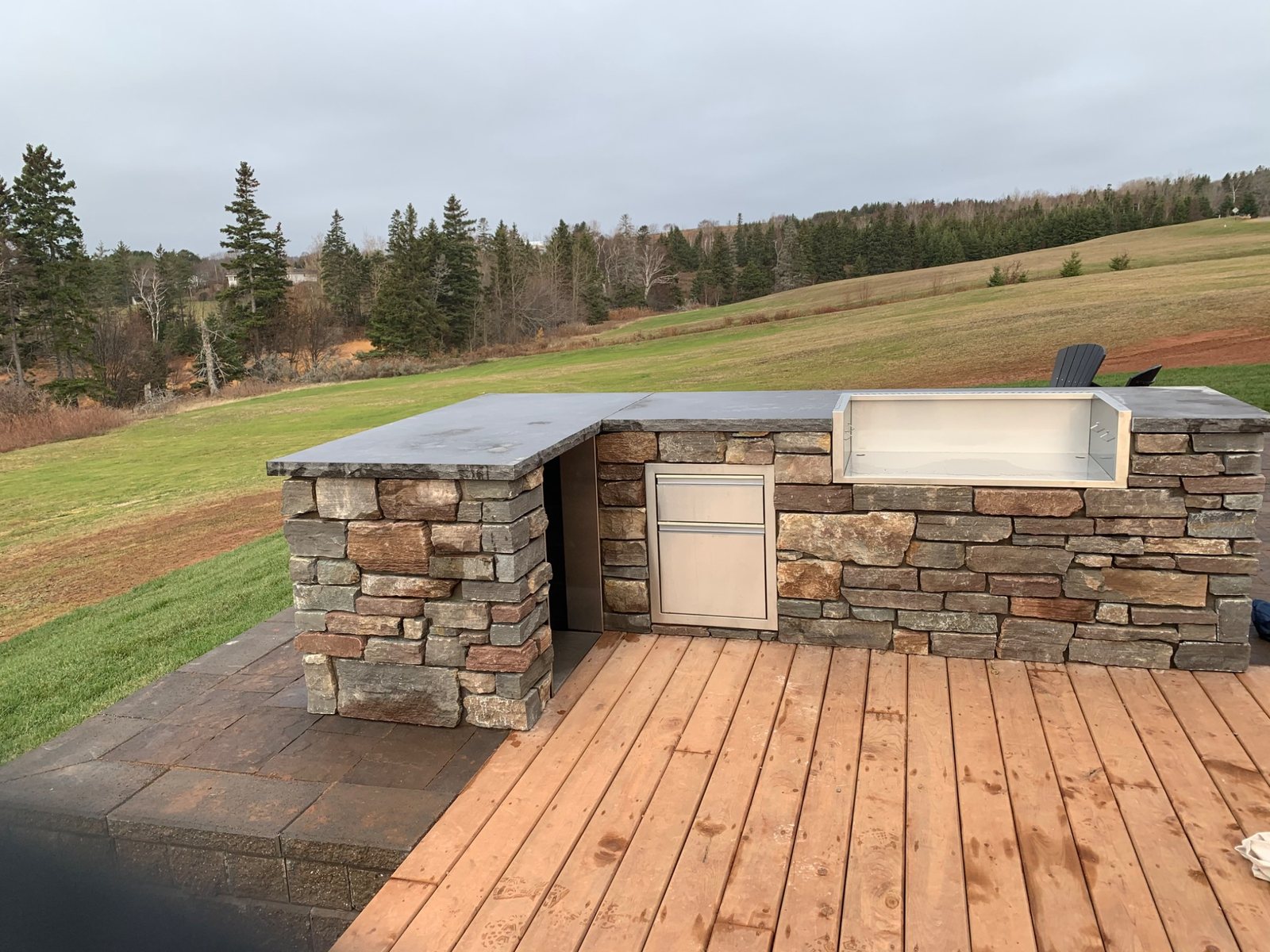 Custom outdoor stone kitchen and masonry living area by DinoMac Masonry